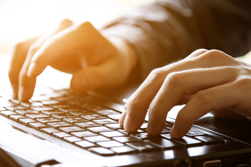 Mature hands working at keyboard